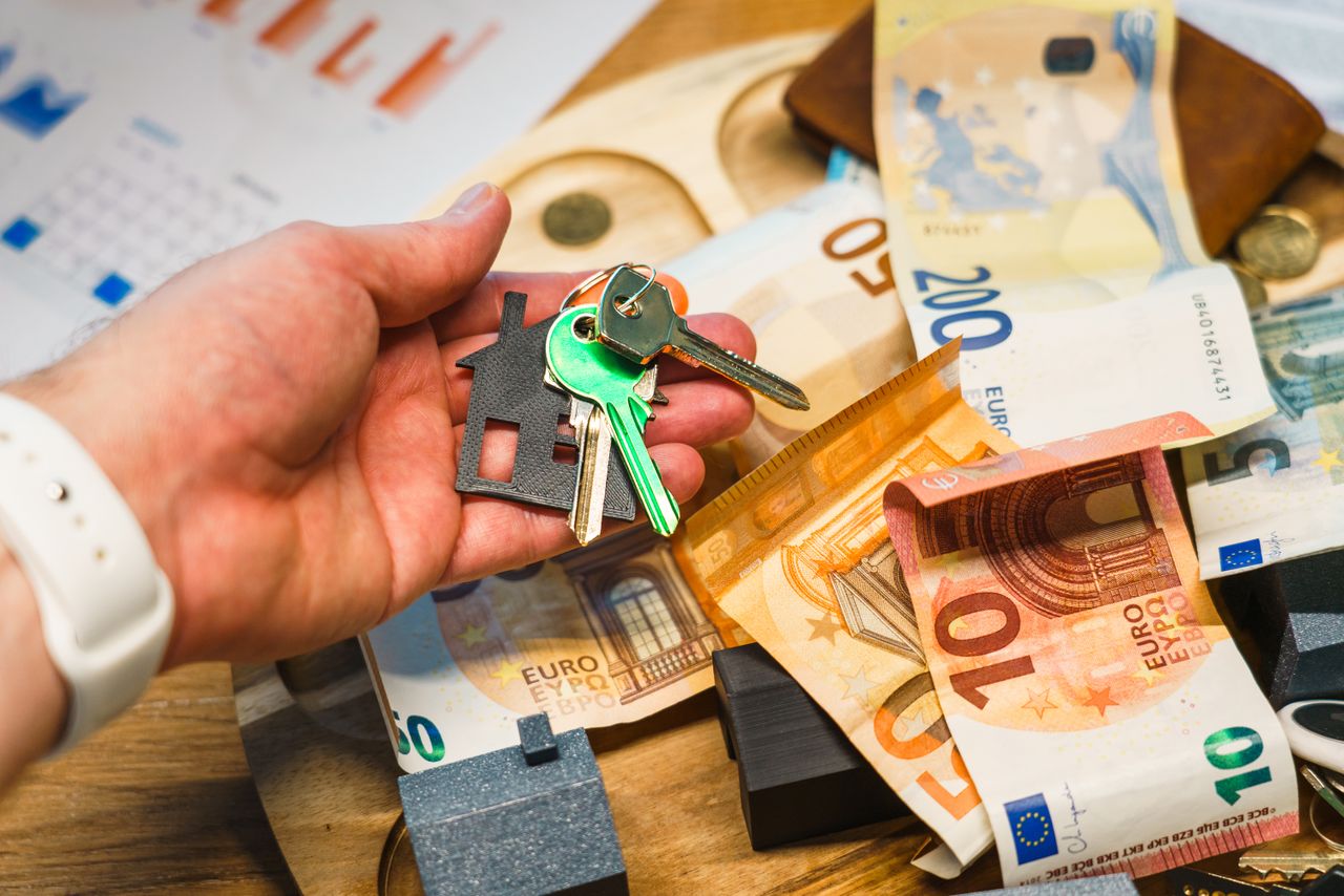 Mastering the First Impression: Your intriguing post title goes here A hand holding house keys over euro banknotes, symbolizing real estate and finance.